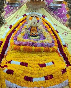 an elaborately decorated altar with flowers and candles on the ground in front of it