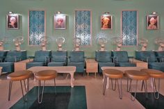 an empty classroom with blue chairs and pictures on the wall