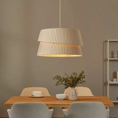 a dining room table with two chairs and a light hanging over it