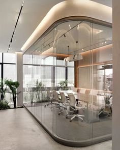 an office with glass walls and white chairs