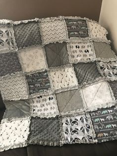 a black and white patchwork quilt on top of a bed next to a pillow