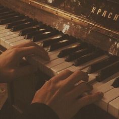 a person is playing the piano with their hands and fingers, while they are sitting down