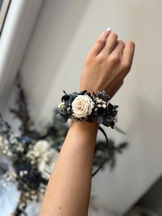 a woman's arm wearing a bracelet with flowers on it