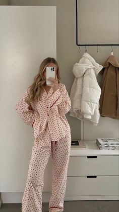 a woman is taking a selfie in her pajamas while standing next to a dresser