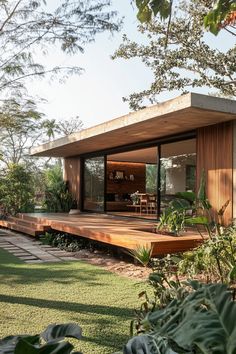 a wooden deck in front of a house surrounded by greenery