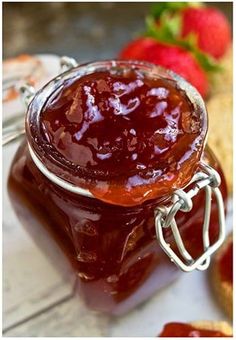 a jar of strawberry jam sitting on top of a table