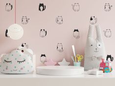 a pink room with black and white cats on the wall