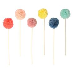 four different colored pom - poms on sticks