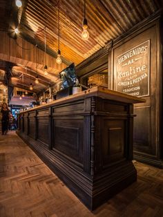 an old fashioned bar with wooden floors and lights