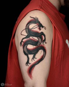 a black and red dragon tattoo on the right arm, shoulder or upper half of a person's arm