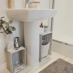 a white sink sitting next to a bath tub in a bathroom