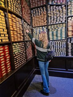 a woman standing in front of a wall full of stacks of papers and folders