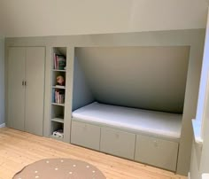 there is a bed in the corner of this room with built - in bookshelves