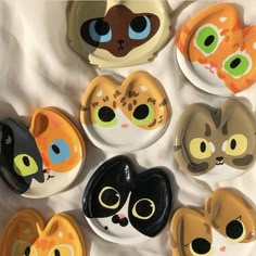 a bunch of plates that have different colored cats on them, one is black and the other is orange