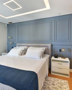 a bedroom with blue walls and white bedding, nightstands and night stands in front of the bed