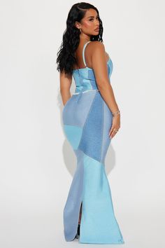 a woman in a blue dress with her back turned to the camera and looking off into the distance