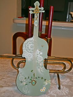 a violin shaped candle holder sitting on top of a table