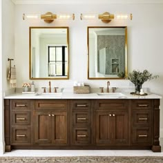 a bathroom with double sinks and two mirrors on the wall next to eachother