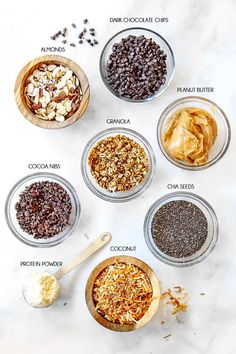 six bowls filled with different types of food on top of a white counter next to spoons