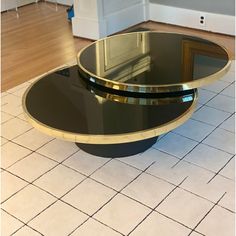 a black and gold coffee table sitting on top of a tiled floor