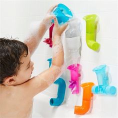 a young boy washing his hands in the bathtub with soap and toothbrushes