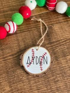 a wooden ornament with baseballs on it next to a string of christmas ornaments