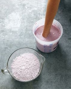 a person mixing pink powder into a bowl