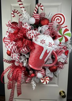 a christmas wreath with candy canes, coffee mug and candies on the front door