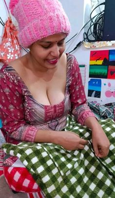 a woman in a pink hat is sewing