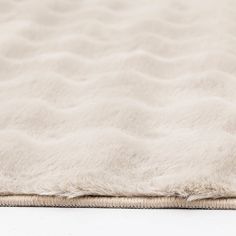 a close up view of a mattress with white fur on the top and bottom edge