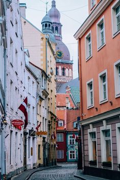 an old city street with buildings and a clock tower in the backgroung