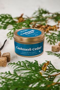 a can of cashmere cedar surrounded by pine cones