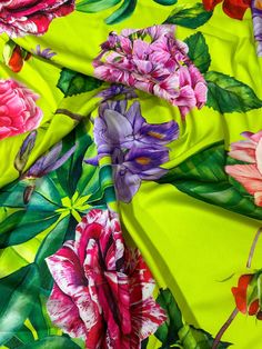 a green and pink flowered fabric with large flowers on the bottom half of it