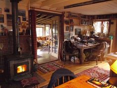 a living room filled with furniture and a fire place next to a dining table on top of a wooden floor