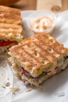 the grilled chicken panini is cut in half and ready to be eaten on the table