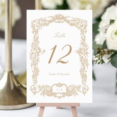 the table numbers are displayed on an easel with flowers in vases behind them