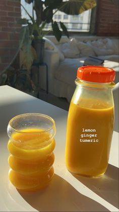 a jar of orange juice next to a glass bowl