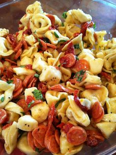 a bowl filled with pasta and vegetables on top of a table