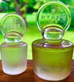 two glass bottles sitting on top of a wooden table