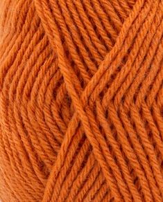 an orange ball of yarn on a white surface