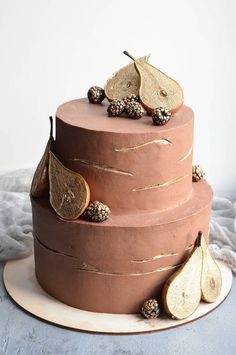 a three tiered cake decorated with leaves and acorns