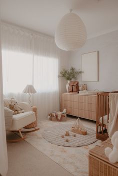 a baby's room with a crib, rocking chair and dresser in it