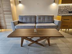 a couch and table in a room with lights on the wall above it, along with other furniture