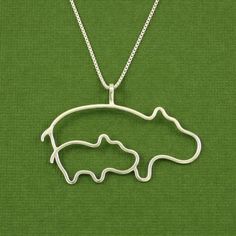 a silver necklace with an image of a bear in the shape of a fish on it