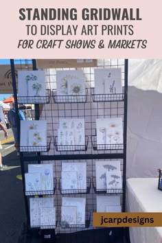 an outdoor stand with greeting cards on it and the words standing gridwall to display art prints for craft shows & markets