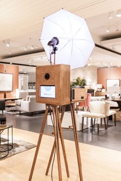 an umbrella is placed on top of a tripod in the middle of a room