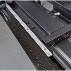 a machine that is cutting metal with a ruler