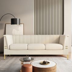 a living room with a white couch and two tables in front of a wall that has vertical slats on it