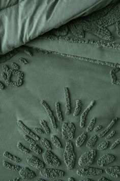 an image of a bed with green sheets and pillow cases on top of each other