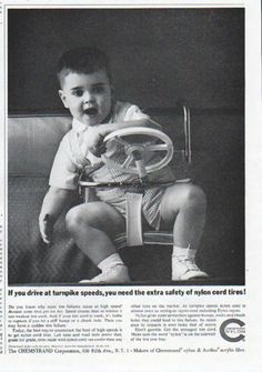 an article in the paper shows a baby sitting on a chair holding a tennis racquet